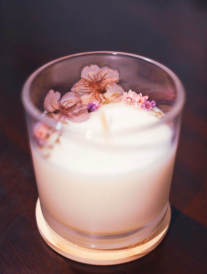 contact-img A cozy candle with cherry blossoms creating a soothing aromatic atmosphere indoors.