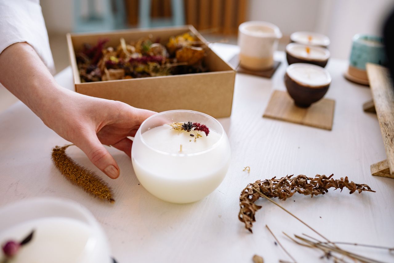 A close-up of a handmade candle adorned with dried flowers, perfect for craft and decor enthusiasts.