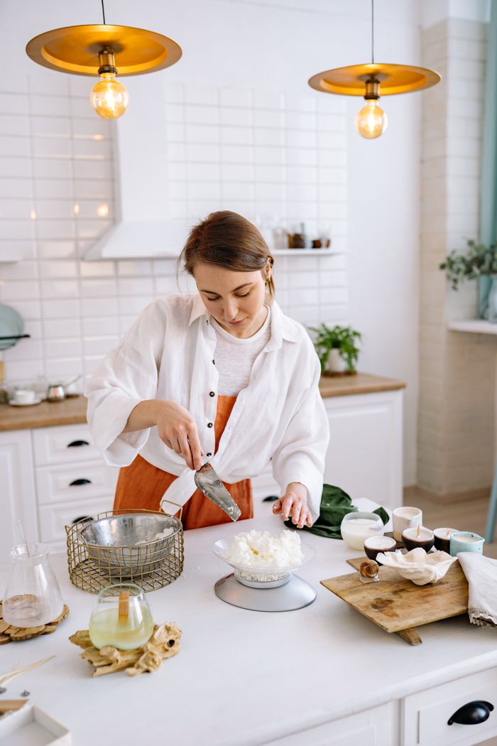 Woman crafting candles in a cozy home workshop, focusing on craftsmanship.